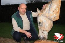 Wim naast een houten maar bijna levensechte paardenkop.