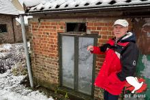De buitenzijde van het weduwnaarshok met boven het raam de ingang met spoetnik.